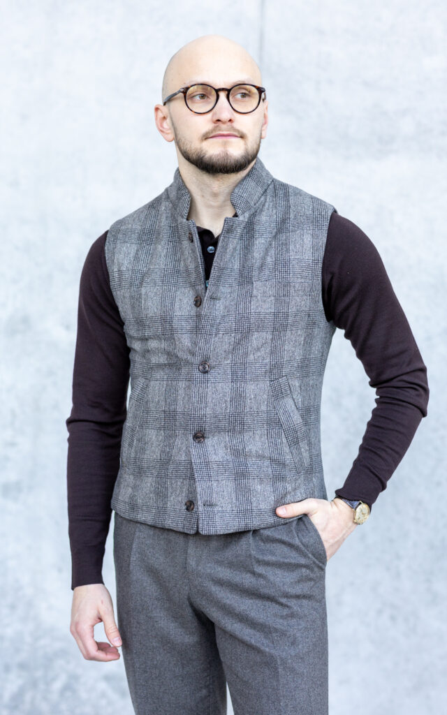 Ocieplana kamizelka w kratę beż Ten model został wykonany z flaneli wełnianej od renomowanego producenta VBC. Dzięki wysokiej jakości materiałom oraz dopasowanemu krojowi, kamizelka świetnie komponuje się zarówno w casualowych stylizacjach, jak i jako dodatek do eleganckiego zestawu z marynarką. Cechy produktu: Tkanina wierzchnia: 100% flanela wełniana od VBC Podszewka: wiskoza Wypełnienie: ocieplina syntetyczna – zwiększa trwałość konstrukcji i komfort termiczny Dopasowany krój Kieszenie po skosie