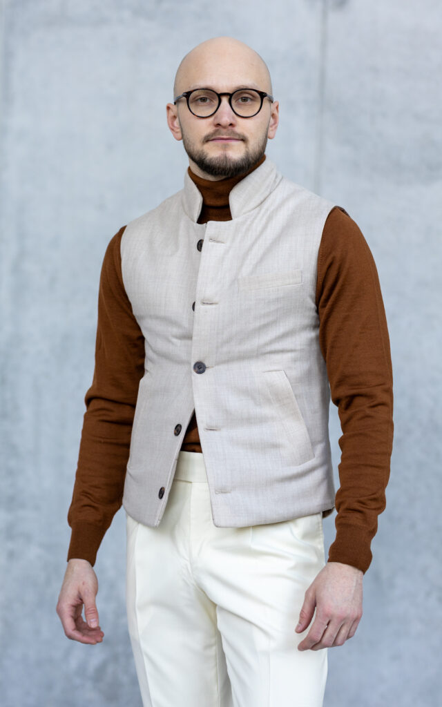 Ocieplana kamizelka z flaneli Botto Wykonana z beżowej flaneli od włoskiego producenta Botto, kamizelka ta łączy klasykę z funkcjonalnością. Dzięki ocieplinie syntetycznej jest idealnym wyborem na co dzień, zapewniając komfort i styl niezależnie od okazji. Cechy produktu: Tkanina wierzchnia: 100% flanela wełniana od Botto Podszewka: wiskoza Wypełnienie: ocieplina syntetyczna – zapewnia trwałość i ciepło Dopasowany krój Kieszenie po skosie