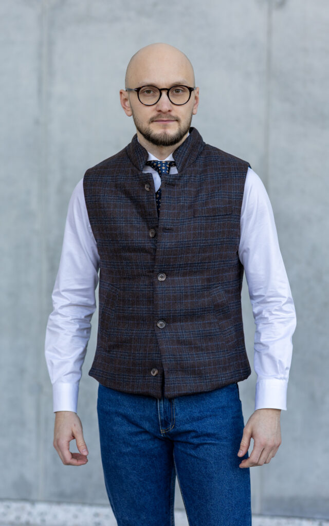 Ocieplana kamizelka z flaneli Reda Kamizelka uszyta z najwyższej jakości flaneli od uznanego włoskiego producenta Reda to propozycja dla mężczyzn, którzy cenią sobie nie tylko ciepło, ale i ponadczasową elegancję. Jej uniwersalny charakter pozwala na noszenie zarówno w stylizacjach codziennych, jak i bardziej formalnych. Cechy produktu: * Tkanina wierzchnia: 100% flanela wełniana od Reda * Podszewka: wiskoza * Wypełnienie: ocieplina syntetyczna – zapewnia trwałość i komfort użytkowania * Dopasowany krój * Kieszenie po skosie